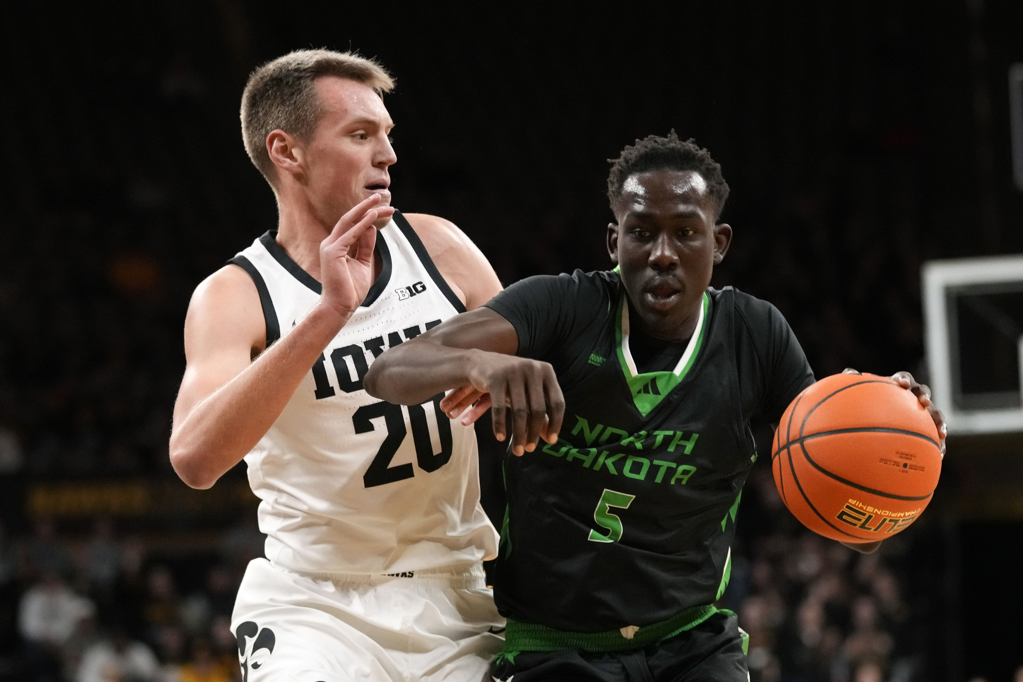 North Dakota forward Deng Mayar (5) drives past Iowa forward Payton Sandfort (20) during the first half of an NCAA college basketball game